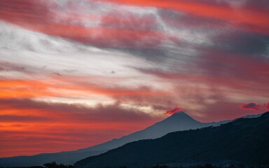 Silhouette view of Colima volcano under colorful dusk sky as seen from Tuxpan, Jalisco, Mexico