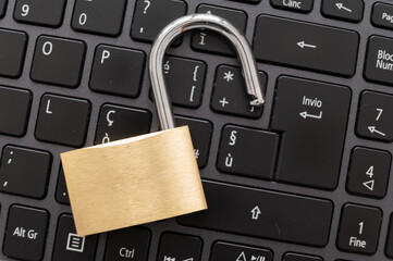 Open padlock, placed above a pc keyboard. Protection of personal and sensitive data, risk of intrusion. Privacy.
