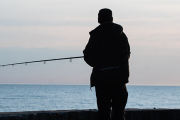 Anglers catch fish in the sea at sunset