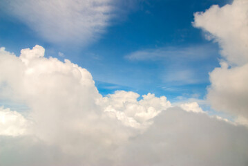 Fluffy clouds. Beautiful dramatic sunset sky above fluffy clouds in early morning from aerial drone view. Traveling by air. View from an airplane window. Aerial view of Malaysia.White clouds floating 