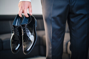 Mężczyzna trzyma eleganckie buty