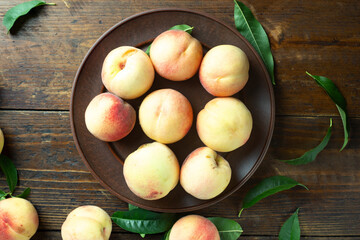 A group of ripe peaches in a bowl