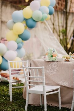 Vertical shot of the beautiful Easter table with egg cakes and balloons in the background