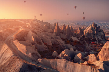 Old ancient home cave in big stone, hot air balloons fly over deep canyons, valleys Cappadocia...