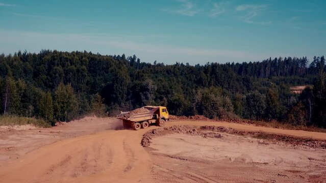 Dump truck driving. Dust and smoke in the air. Beautiful scenery. 4k.