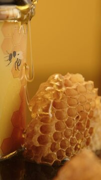 Honey flows down the honeycomb. Photo of a jar of honey