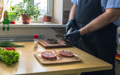 Man making hamburger patties at the table, close-up