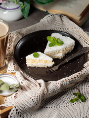 Dessert on a wooden tray and vintage lace napkin. cheesecake with coconut.