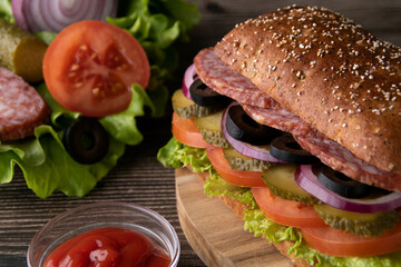 photo onions, pickled cucumber, olives, salami, green salad on a bun