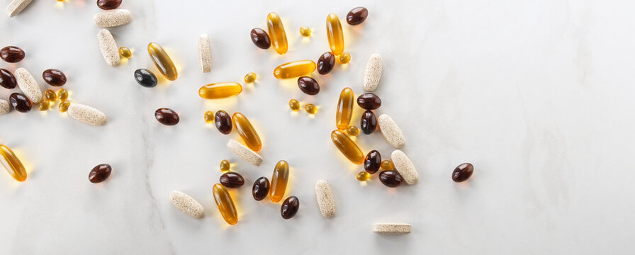 Various Capsules With Vitamins And Supplements On A Light Table, Space For Text