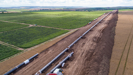Aerial view of gas and oil pipeline construction. Pipes welded together. Big pipeline is under...