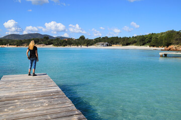 A woman is watching the crystal clear water in Capo Ceraso, Sardinia 