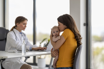 Obraz premium Mother with little baby visiting pediatrician in clinic