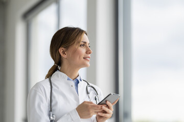 Portrait of female doctor in her office with smartphone