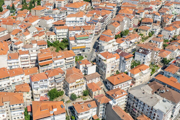 Obraz premium Aerial view of traditional village with rural houses, white buildings with orange roofs in Greece. Drone, copter view