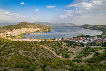 Landscape of countryside town, village and lake of Orestiada in Kastoria during summer sunny day over a mountain peak in Greece. Aerial, drone, top view. Panorama