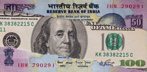 100 dollar banknote through torn Indian rupee banknote