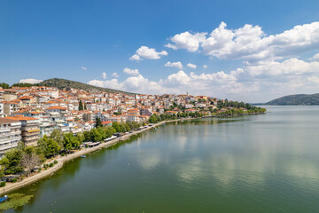 Fototapeta premium Aerial view of traditional village with rural houses, white buildings with orange roofs in the middle of lake. Greece. Drone, copter view