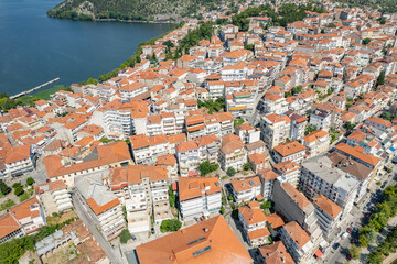 Naklejka na ściany i meble Aerial view of traditional village with rural houses, white buildings with orange roofs in the middle of lake. Greece. Drone, copter view