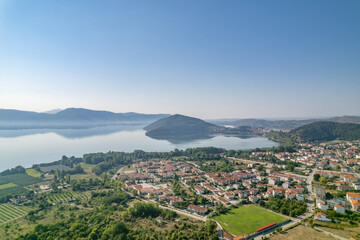 Fototapeta na wymiar Landscape of countryside town, village and lake of Orestiada in Kastoria during summer sunny day over a mountain peak in Greece. Aerial, drone, top view. Panorama