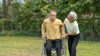 A wife helping her elderly husband patient use a walker to learn to walk. Elderly couple. Asian elderly couple giving love to each other smiling happily. Love and care for each other.