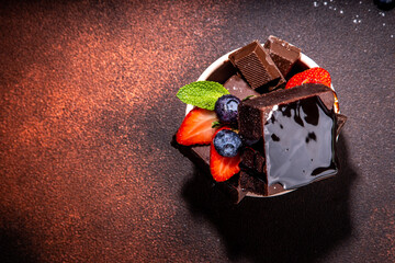 Dark chocolate brownies with berries. Stack of homemade brownie cake cookies with chocolate sauce...
