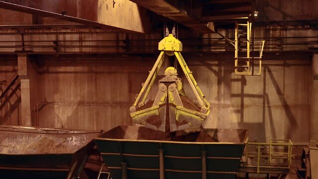 Follow shot of clamshell opening and dropping the load of clay. Slow motion 50perc. 4k.