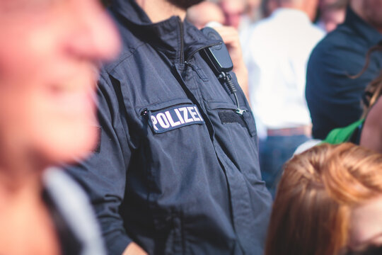German police squad formation in protective gear with "Police" logo on uniform maintain public order after football game and political protest rally in the streets of Berlin city center, Germany