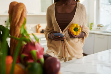 Woman making new order of fresh groceries via mobile app