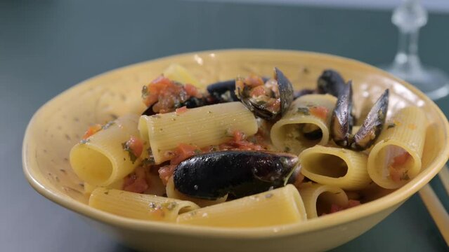Italian pasta paccheri allo scoglio with mussels. Large Italian pasta with mussels and shrimps in sauce. From the South of Italy, typical Neapolitan pasta with seafood. High quality 4k footage