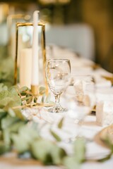 Vertical shot of a glass and a candle on the decorated set table for wedding party