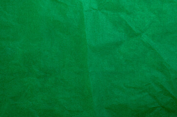 Crumpled dark green tracing paper as texture, holiday backdrop or background, square picture