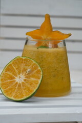orange and star fruit smoothie in a clear glass. fruit drinks that contain vitamin C, fiber, and...