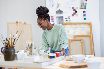 Young artist working in her painting studio