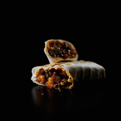 Traditional mexican food, meat and bean burrito, selective focus of beef steak burrito with vegetables