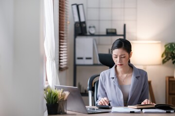 Creative Asian young woman working on laptop in her office.