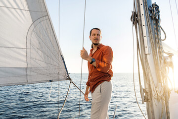 Young handsome man during  on his sailboat  during sailing in sea