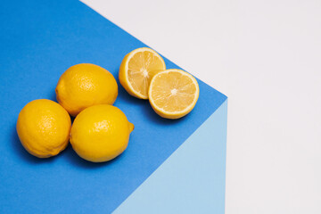 Fresh lemons on bright blue table, vitamins and healthy eating concept