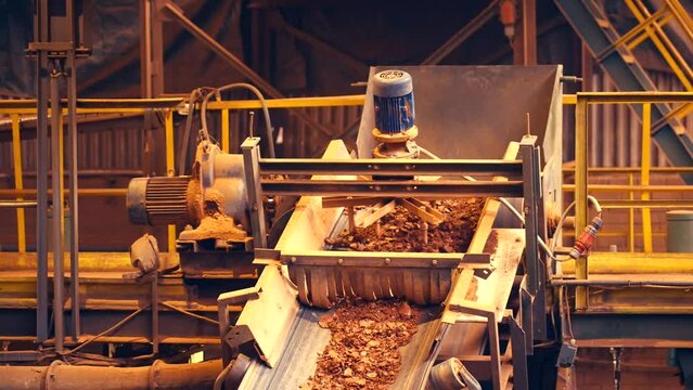 Static shot of tedding clay stones in large brick factory. Slow motion 25perc. 4k.