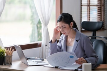 Creative Asian young woman working on laptop in her office.