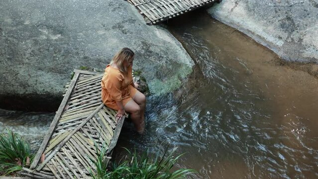Asian fat woman Tourist stiing on bamboo bridge handmade at vacation holiday natural waterfall. Tourism travel and vacation concept