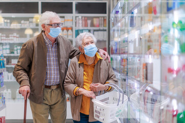 Senior couple looking for medicine in pharmacy store.