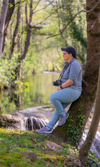 A woman taking pictures of a lake and the lake. Travel and hobbies concept