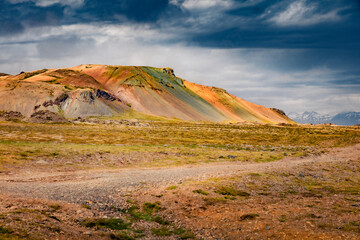 Dramatic Icelendic landscape with trekking path and colorful mountain range on background. Sunny outdoors scene of south Iceland, Europe. Unbelievable summer scenery.