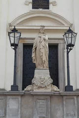 Photo sur Plexiglas Monument historique Vertical shot of female statue with two street lanterns in front of the gate of St. Hyacinths Church
