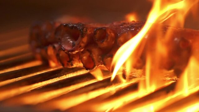 Macro view, octopus tentacles being turned on the grill