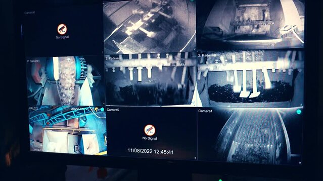 Handheld shot of a CCTV screen in the factory. Machinery teddering, conveyor belts, mash processing. Black and white images. Slow motion 50perc. 4k.