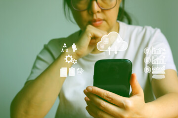Asian woman using mobile phone loading private document on cloud stored .The capabilities of...