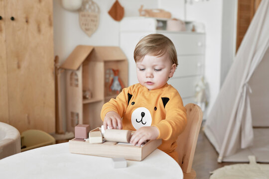 Baby child plays with wooden toys constructor. Early development