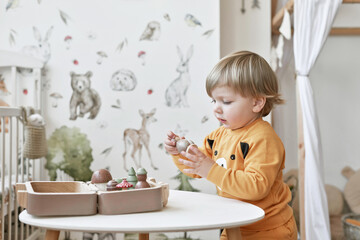 Baby child plays with wooden toys. Early development